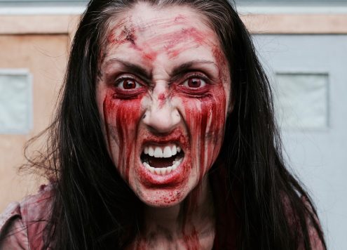 Angry feminist with red paint smeared on her face