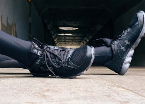 Black trainers on a beige carpet