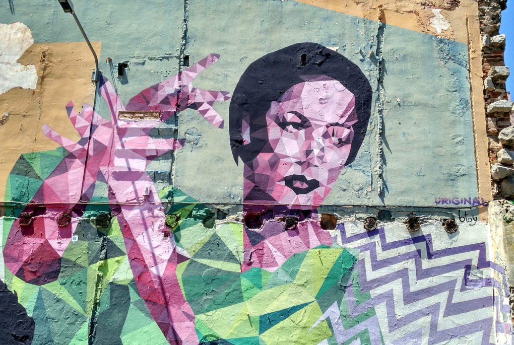Graffiti on a large wall of a woman made up of colourful geometric blocks