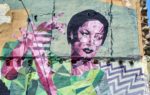 Graffiti on a large wall of a woman made up of colourful geometric blocks
