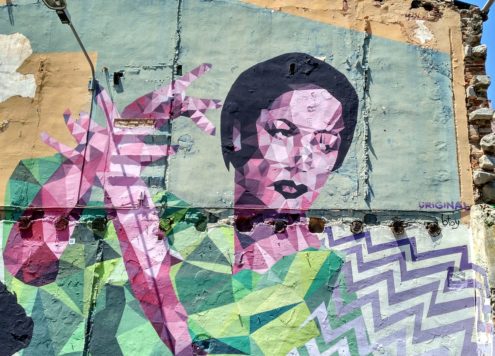 Graffiti on a large wall of a woman made up of colourful geometric blocks