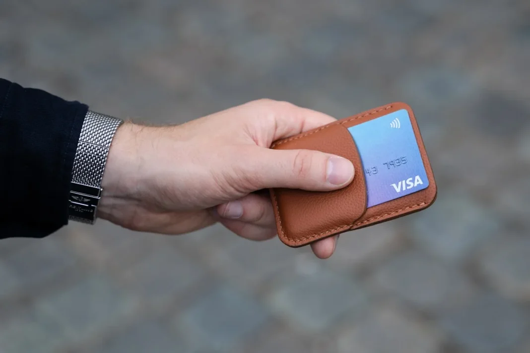 best cashback credit cards no annual fee uk - Photo of a brown card holder in a male hand.